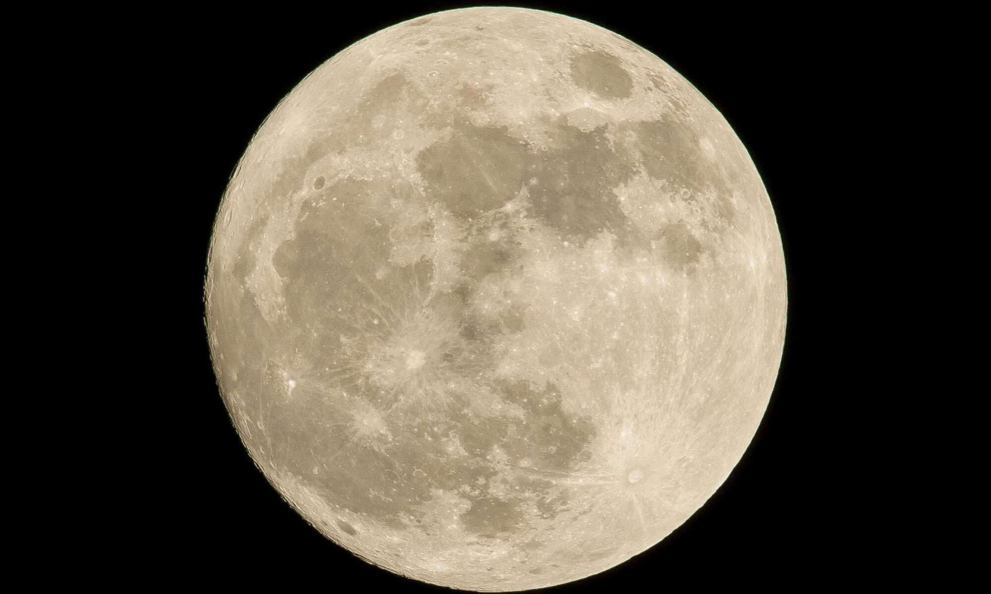 Image shows a picture of the moon white with grey shadows on its surface against a black sky